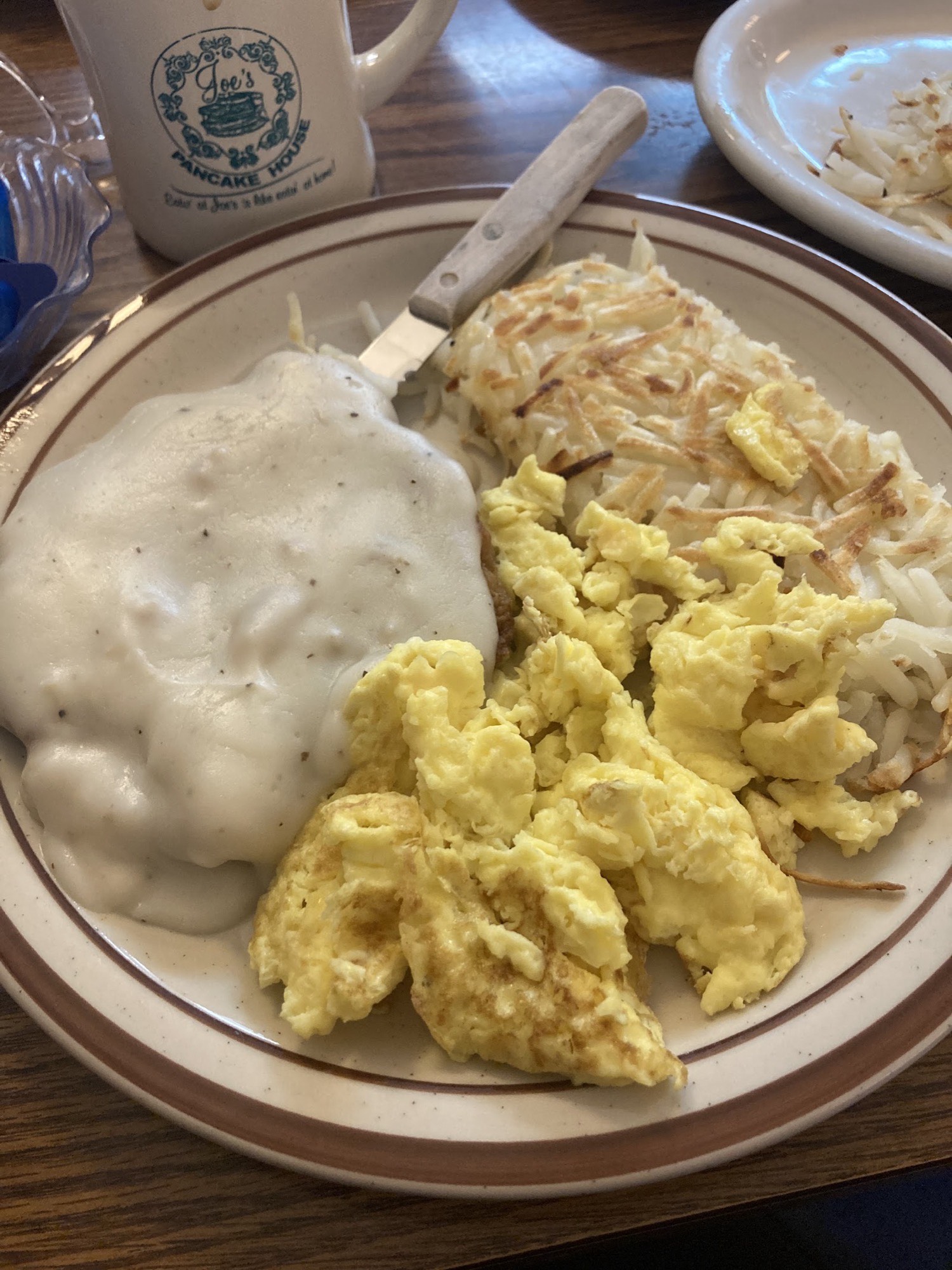 Chicken-fried steak under country gravy with scrambled eggs and hash browns.