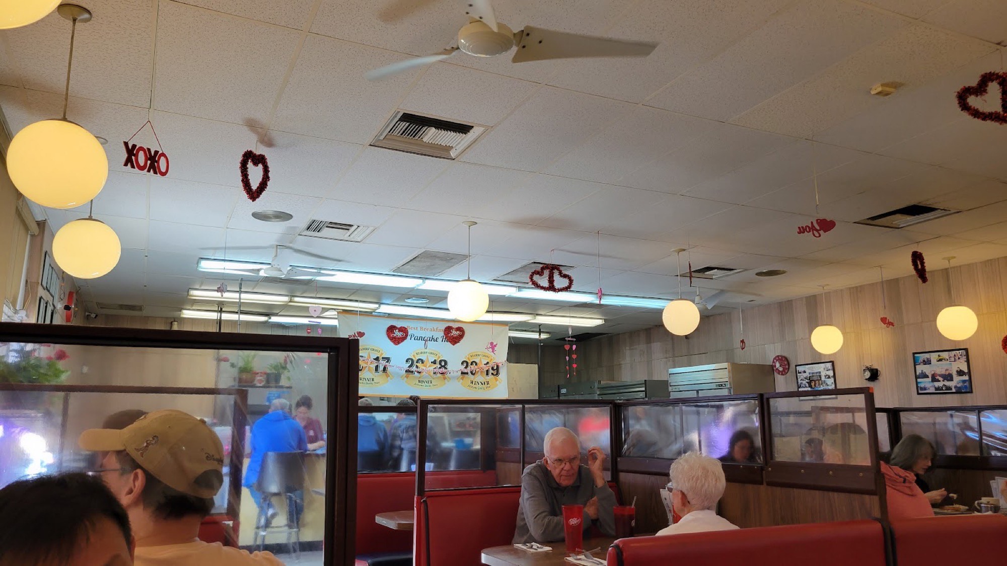 Inside the dining room, with red vinyl booths, globe pendant lights and the Readers’ Choice Best Breakfast banner on the back wall.