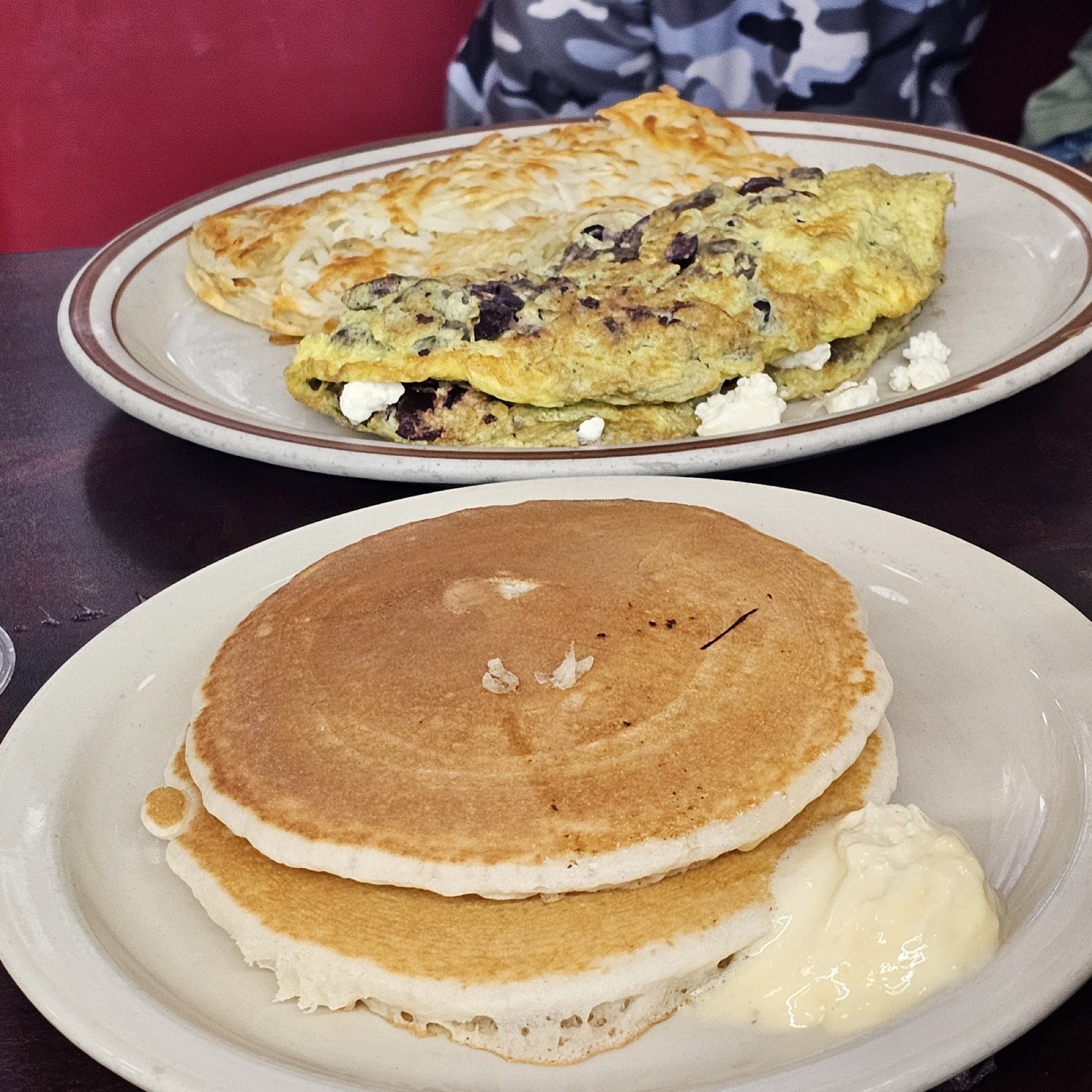 An illustration of a stack of buttermilk pancakes with a pat of butter and a pour of maple syrup.